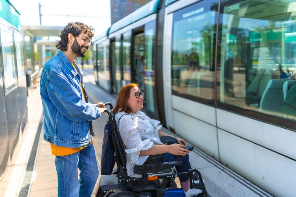 A young man helping a woman in a wheelchair board a train